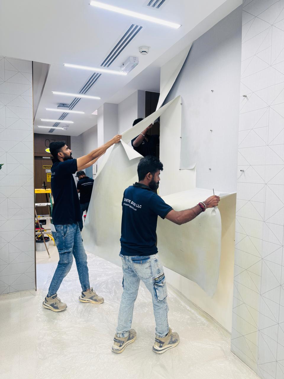 Installers applying wallpaper to a healthcare corridor