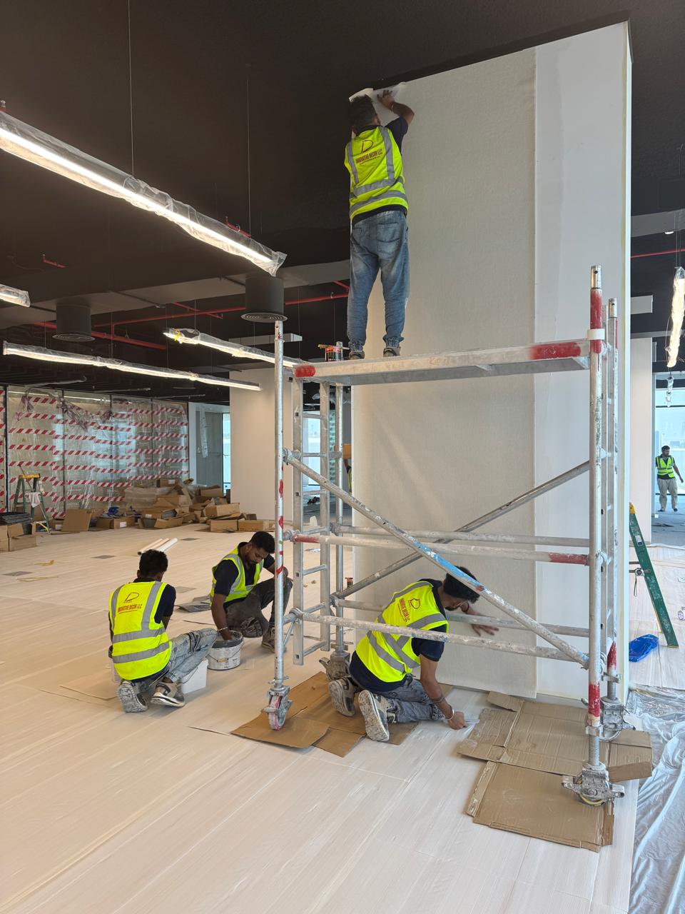 Installers fitting wallcovering in a commercial interior