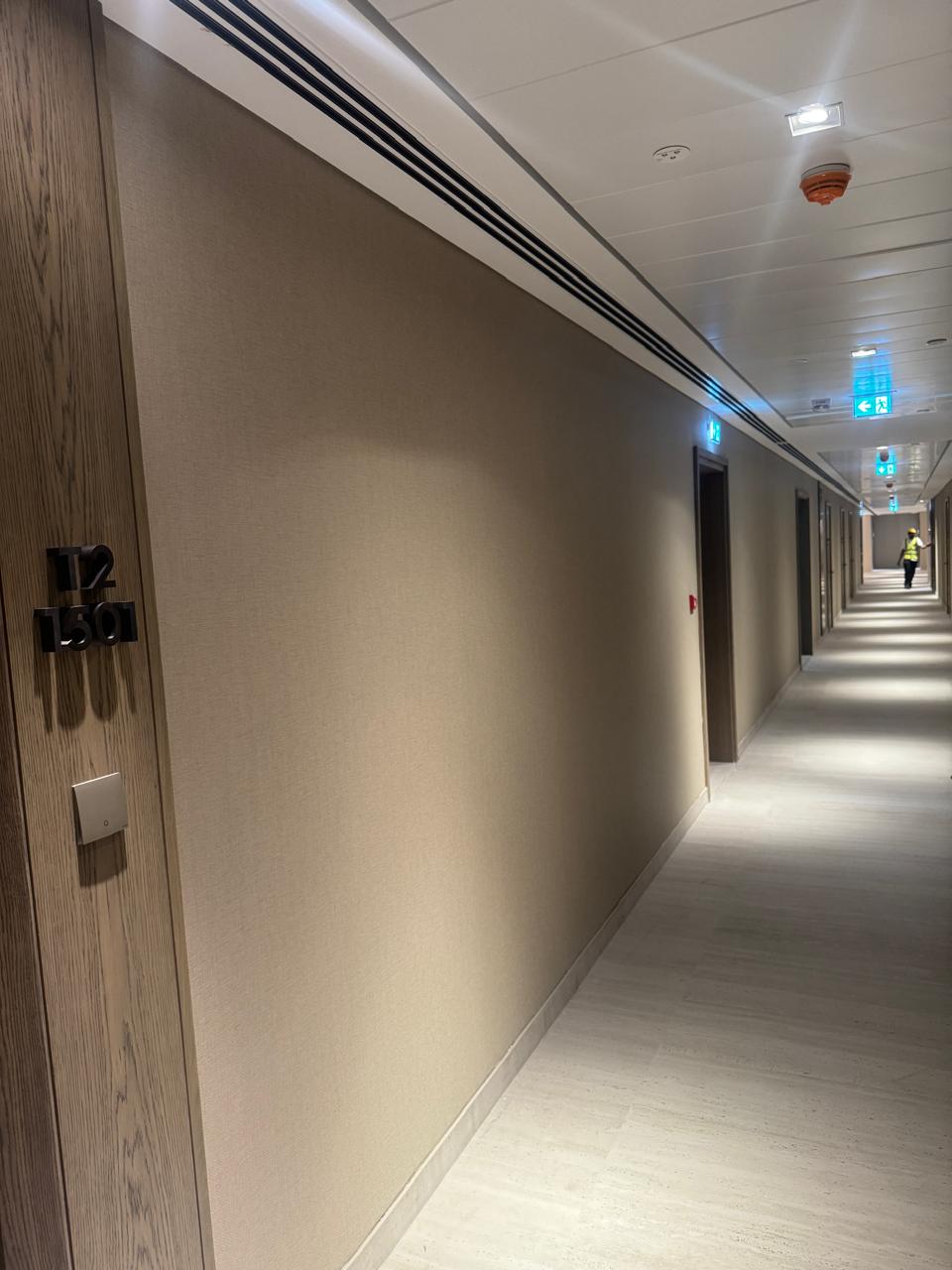 Textured wallpaper installed along a hotel corridor